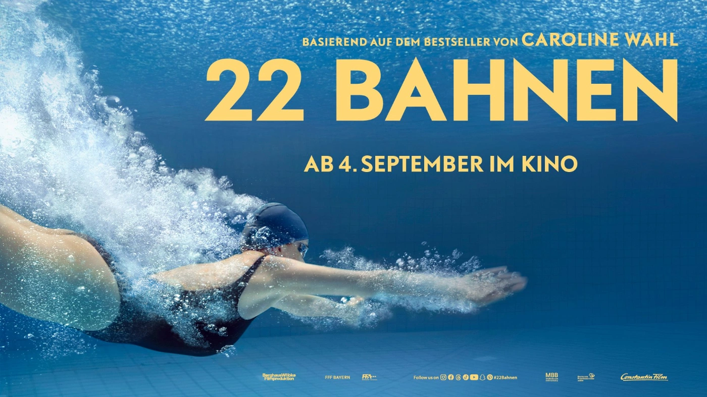 Zu sehen ist eine schwimmende Frau unter Wasser mit Badekappe und Taucherbrille.