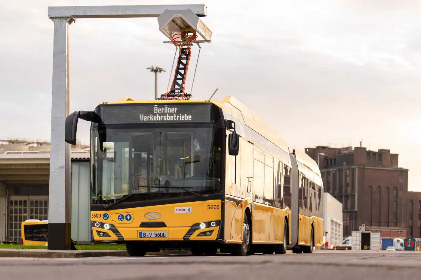 Ein gelber E-Gelenkbus der BVG am Pantographen. 